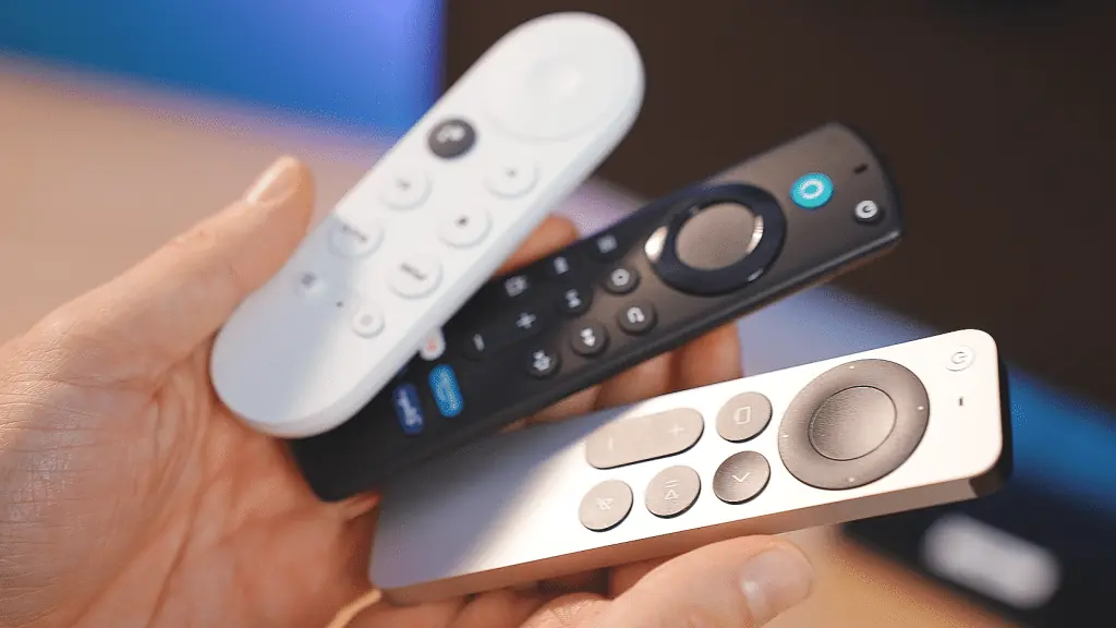 Hände halten Fernbedienungen von Apple TV, Google TV und Fire TV für IPTV Player