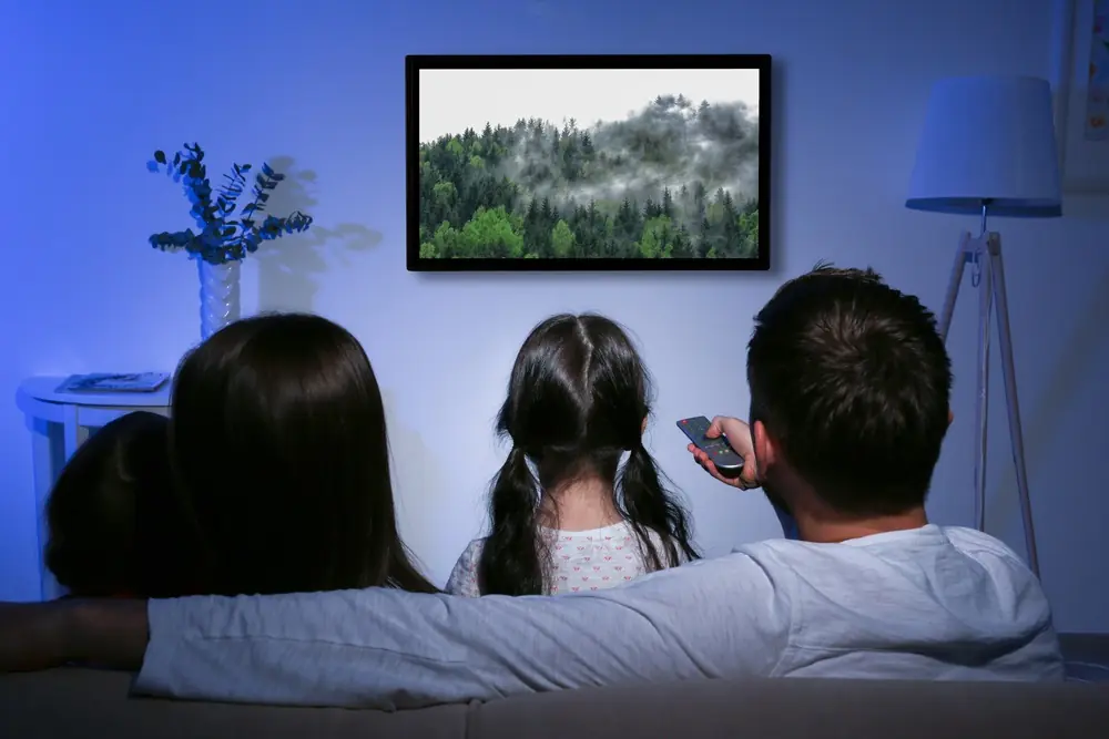 IPTV kaufen in 4K: Familie schaut gemeinsam fern im Wohnzimmer